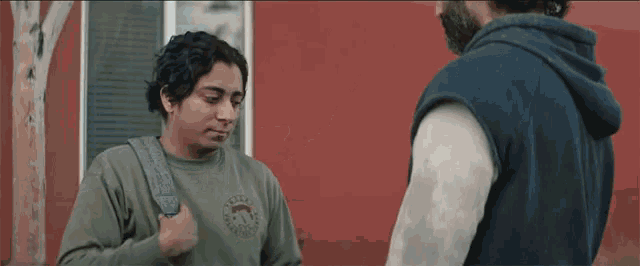 a man wearing a sweatshirt that says ' texas ' on it talks to another man