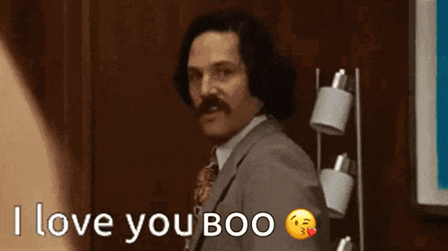 a man in a suit and tie is waving and saying i love you boo