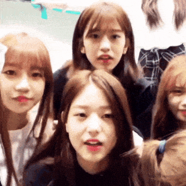 a group of young girls are posing for a picture and one of them is making a funny face