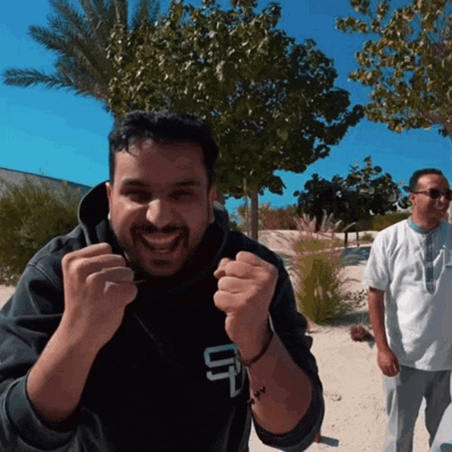 a man wearing a black sweatshirt with the letter u on the front