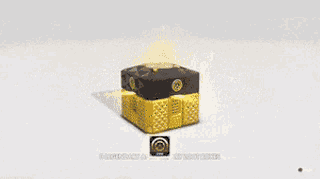 a yellow and black box with a circle on it is sitting on a white surface .