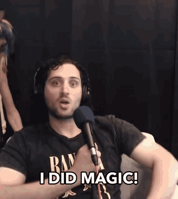 a man wearing headphones and a black shirt that says " i did magic "