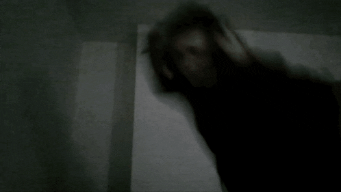 a blurred image of a person standing in a dark room