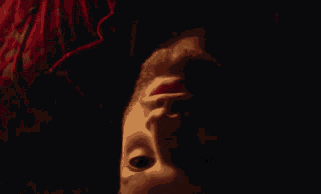 a man with a beard is laying upside down in a dark room .