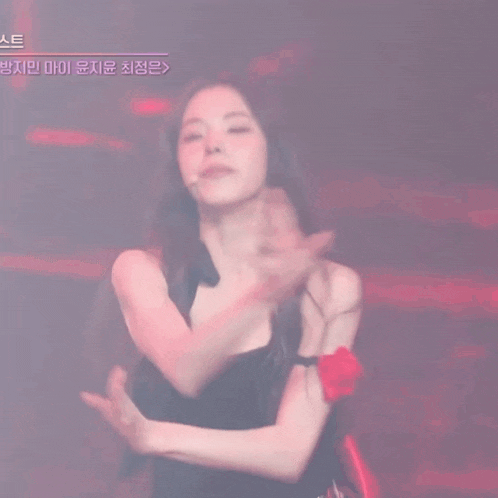 a woman in a black dress is dancing in front of a sign that says ' e ' on it
