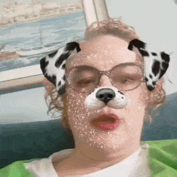 a woman wearing glasses and a dalmatian dog mask on her face .
