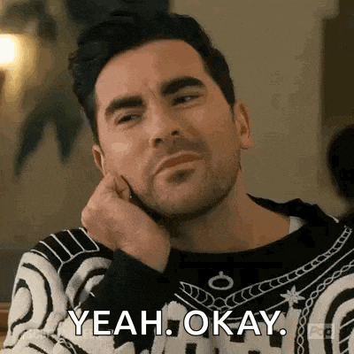 a man is sitting at a table with his hand on his chin and saying yeah okay .