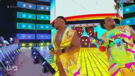two men are dancing on a stage in front of a large screen that says usa
