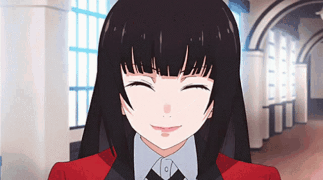 a girl with black hair is smiling and wearing a red jacket
