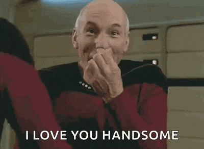 a man is sitting in a chair with his hands folded in front of his face and saying `` i love you handsome '' .