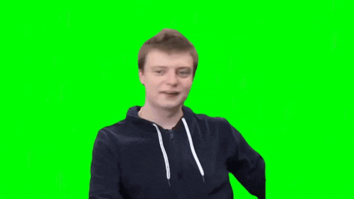 a man in a black hoodie is sitting on a green screen .