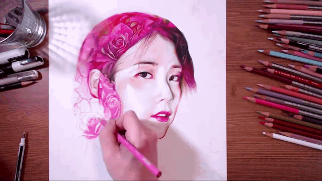 a drawing of a woman 's face with colored pencils on a wooden table