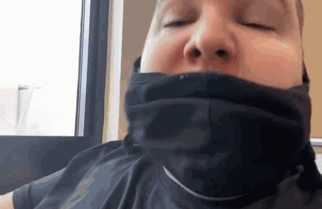a man is wearing a black scarf around his neck .