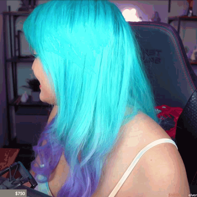 a woman with blue and purple hair is sitting in front of a chair that says net core
