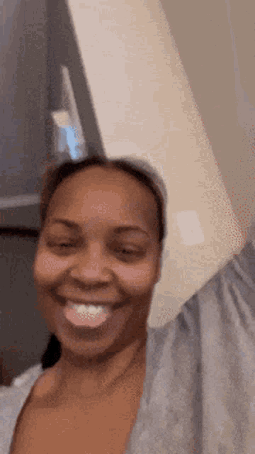 a woman is sticking her tongue out and smiling at the camera