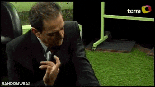 a man in a suit and tie is sitting in front of a tv screen that says terra on it