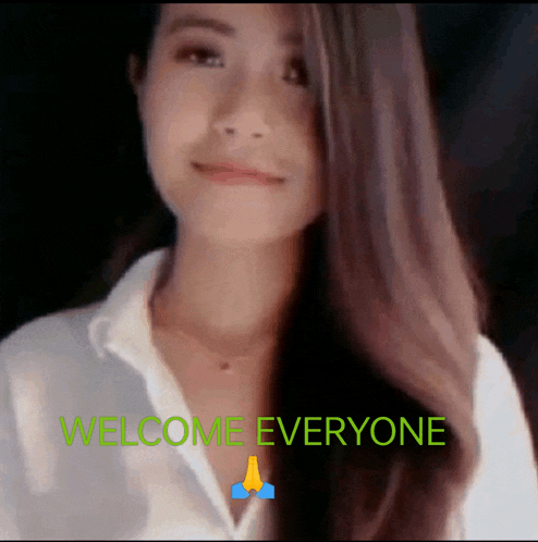 a woman in a white shirt is standing in front of the words welcome everyone