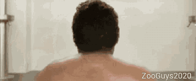 a man is taking a bath in a bathtub with zooguys2020 written on the bottom right