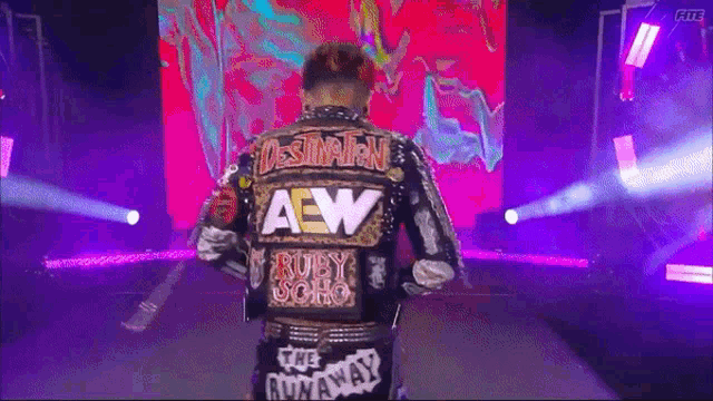 a wrestler wearing a jacket that says destination aew