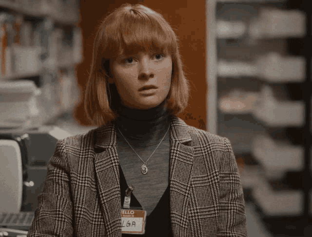 a woman in a plaid jacket has a name tag that says elsa