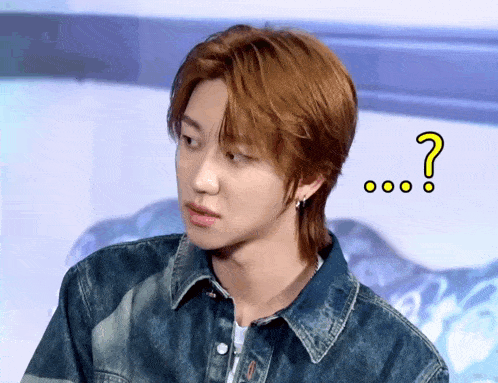 a young man in a denim jacket with a question mark above his head