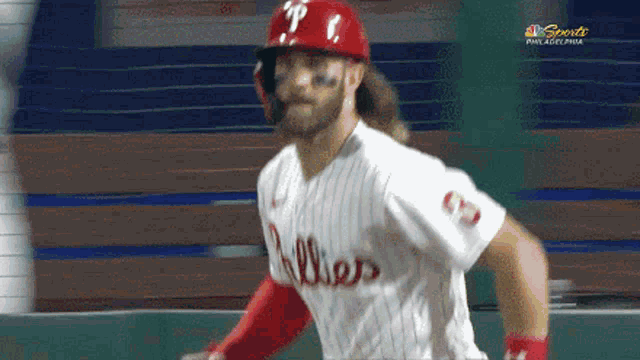 a philadelphia phillies baseball player is running towards the base