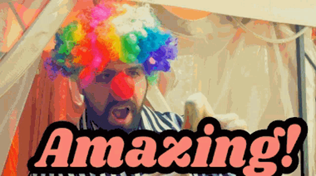 a man wearing a clown wig and red nose is behind a sign that says amazing
