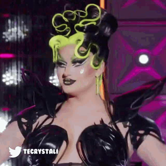 a drag queen is wearing a black and neon green costume