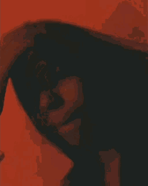 a close up of a woman 's face in a red background