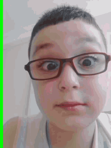 a young boy wearing glasses is making a face