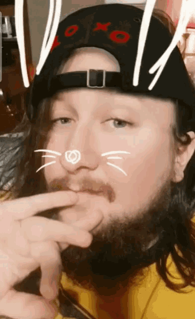 a man with a beard wearing a hat with xoxo on it