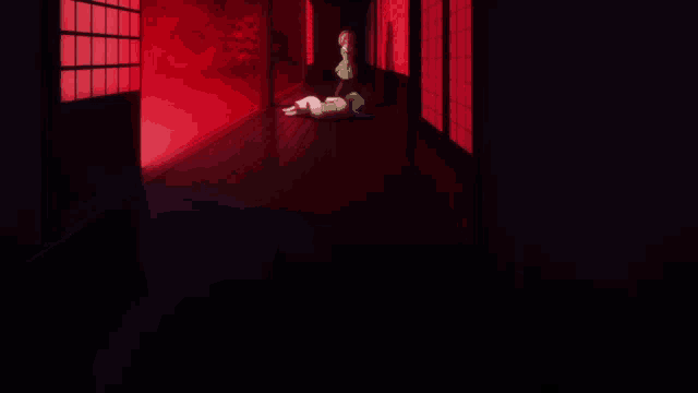 a person is laying on the floor in a dark hallway with red lights