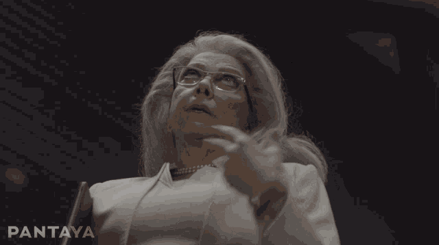 a woman with glasses and pearls says de la que me