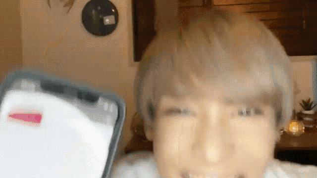 a close up of a person 's face with a phone in front of them