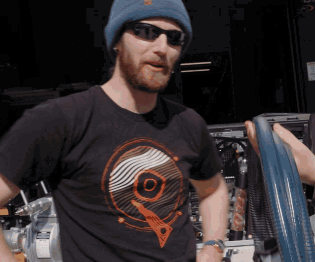 a man wearing a black t-shirt with a circle on it