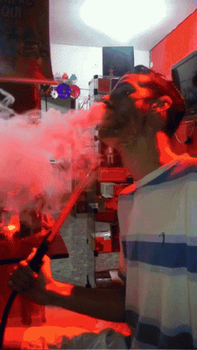 a man is smoking a hookah in front of a sign that says ' coca cola ' on it