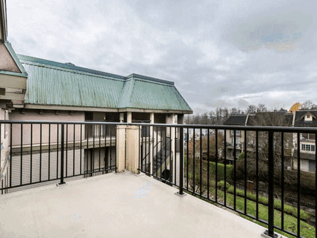 a balcony with a view of a building with a green roof on a cloudy day