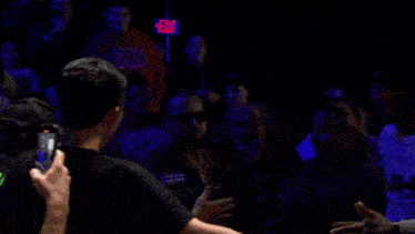 a man wearing a vest that says biker is being lifted by a crowd