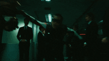 a group of men standing in a dark room