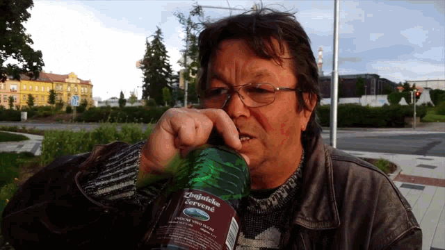 a man is drinking from a bottle that says " zbojnicka cervene " on it