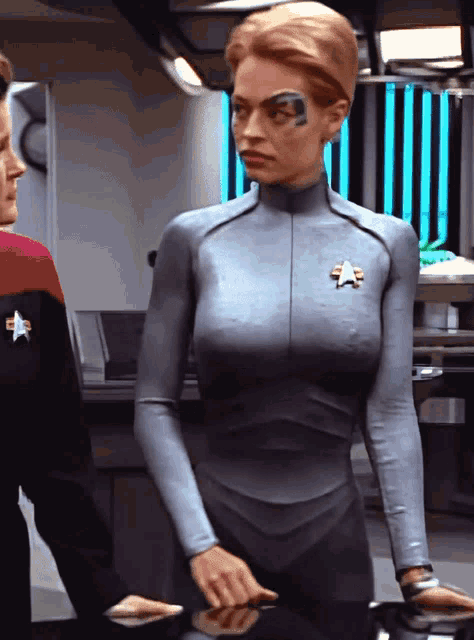 a woman in a star trek uniform has a star on her chest