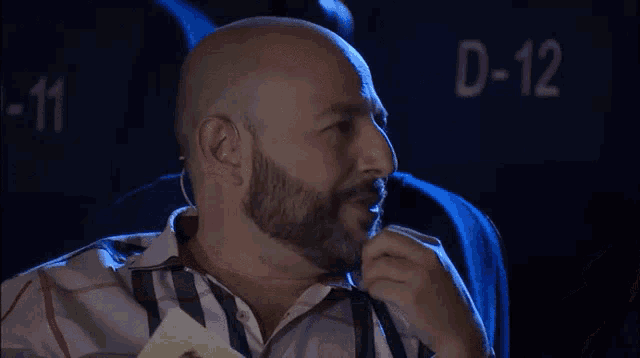 a bald man with a beard is smiling and asking " viste " in a theater