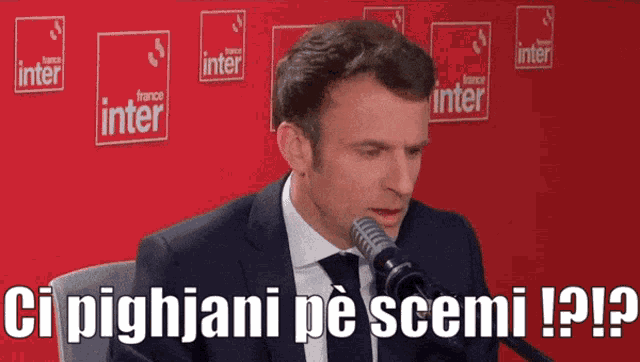 a man in a suit and tie is speaking into a microphone with the words ci pighjani pe scemi written below him