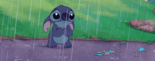 stitch is crying in the rain while standing on the sidewalk .