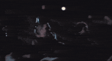 a man in a white shirt is laying on the floor with his arms in the air
