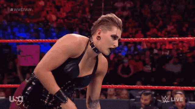 a woman is in a wrestling ring with a sign in the background that says ' usa ' on it