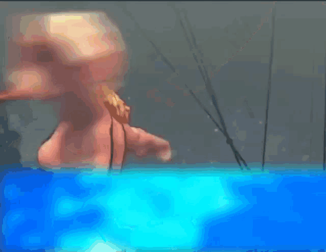 a woman in a bikini is swimming in a pool