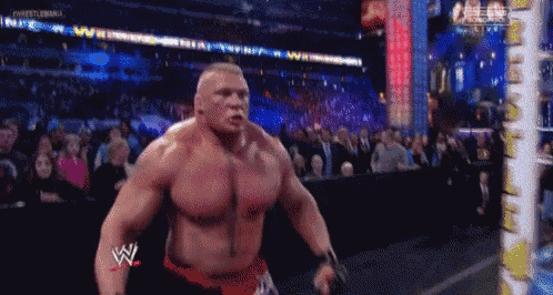 a wrestler is standing in front of a crowd and has a w on his arm