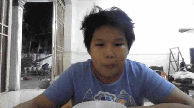a young boy wearing a blue shirt that says ' a ' on it