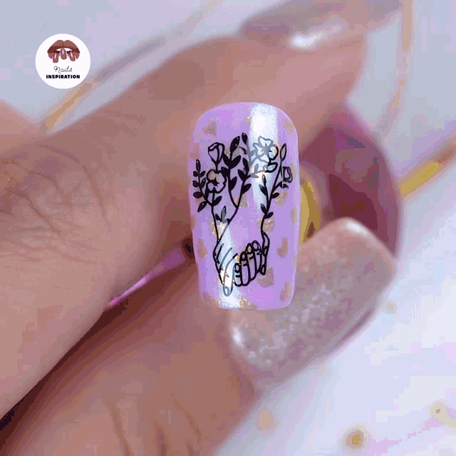 a woman 's nails are painted purple with flowers and leaves on them